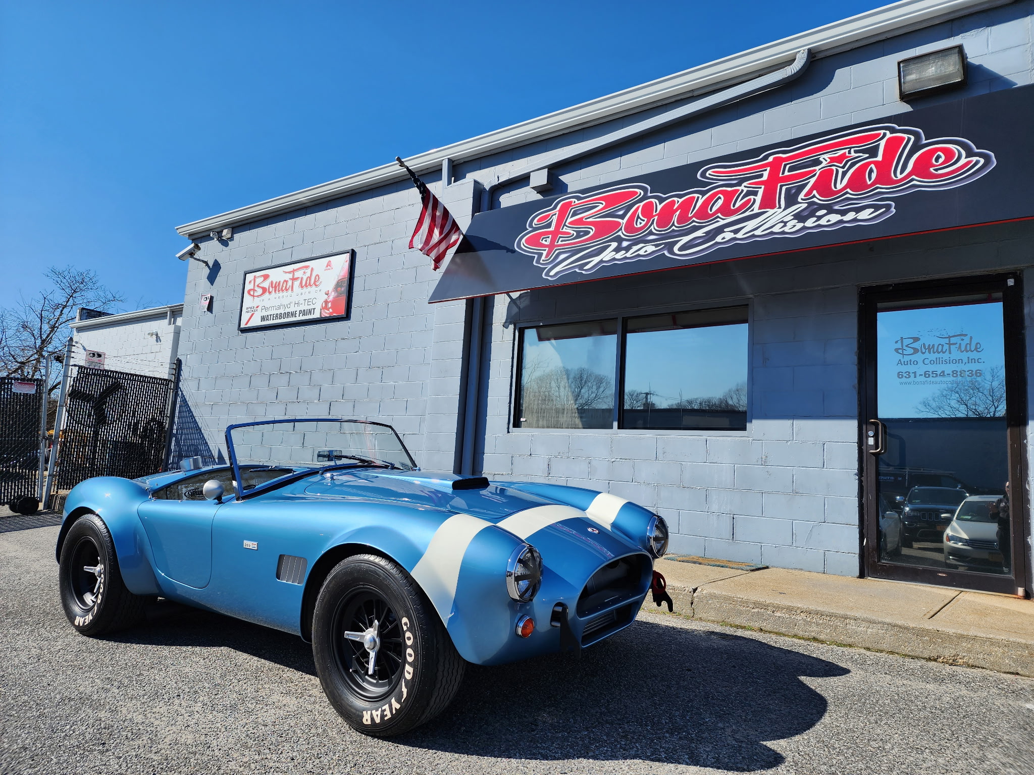 Bonafide Auto Collision shop exterior with a classic blue roadster